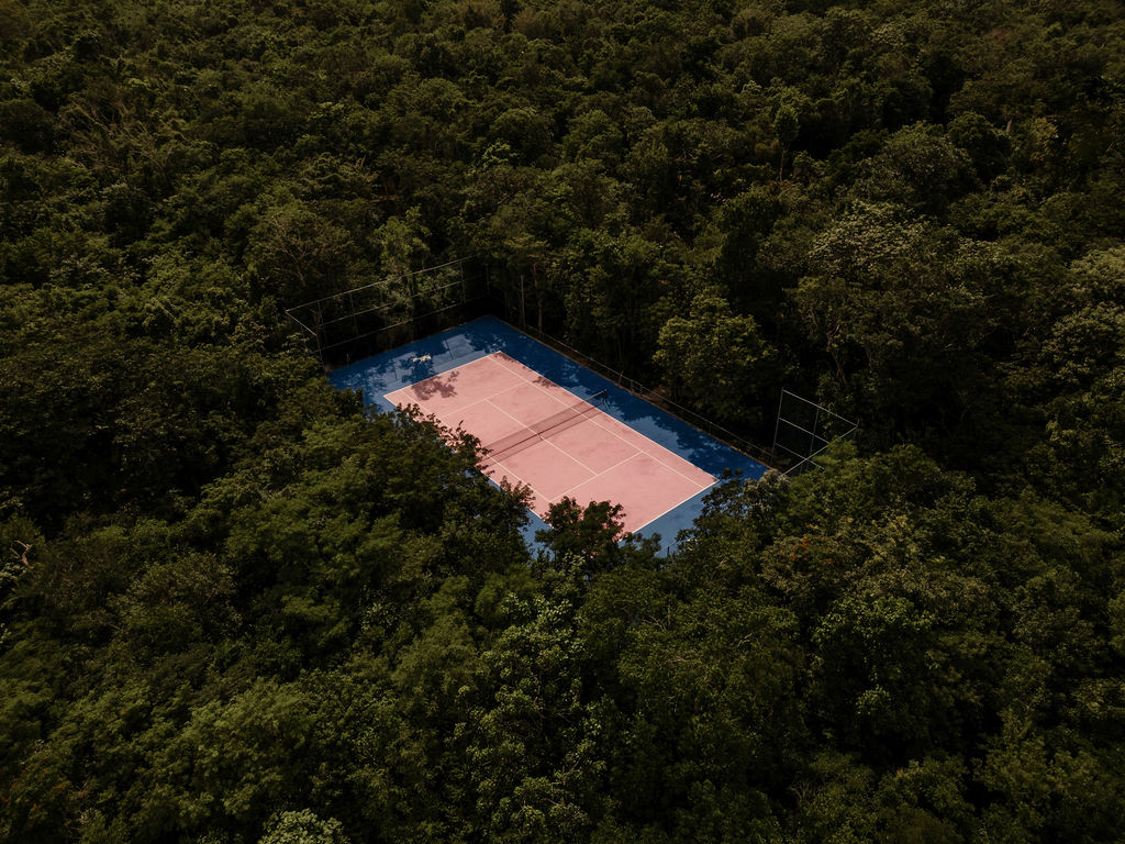 Aerial view of Casa Xolo's pink tennis court set deep in the Tulum jungle